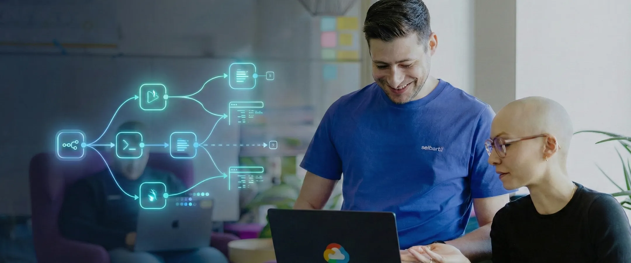 Zwei Personen arbeiten lächelnd gemeinsam an einem Laptop mit grafischen Symbolen zu Automatisierungsabläufen im Hintergrund.