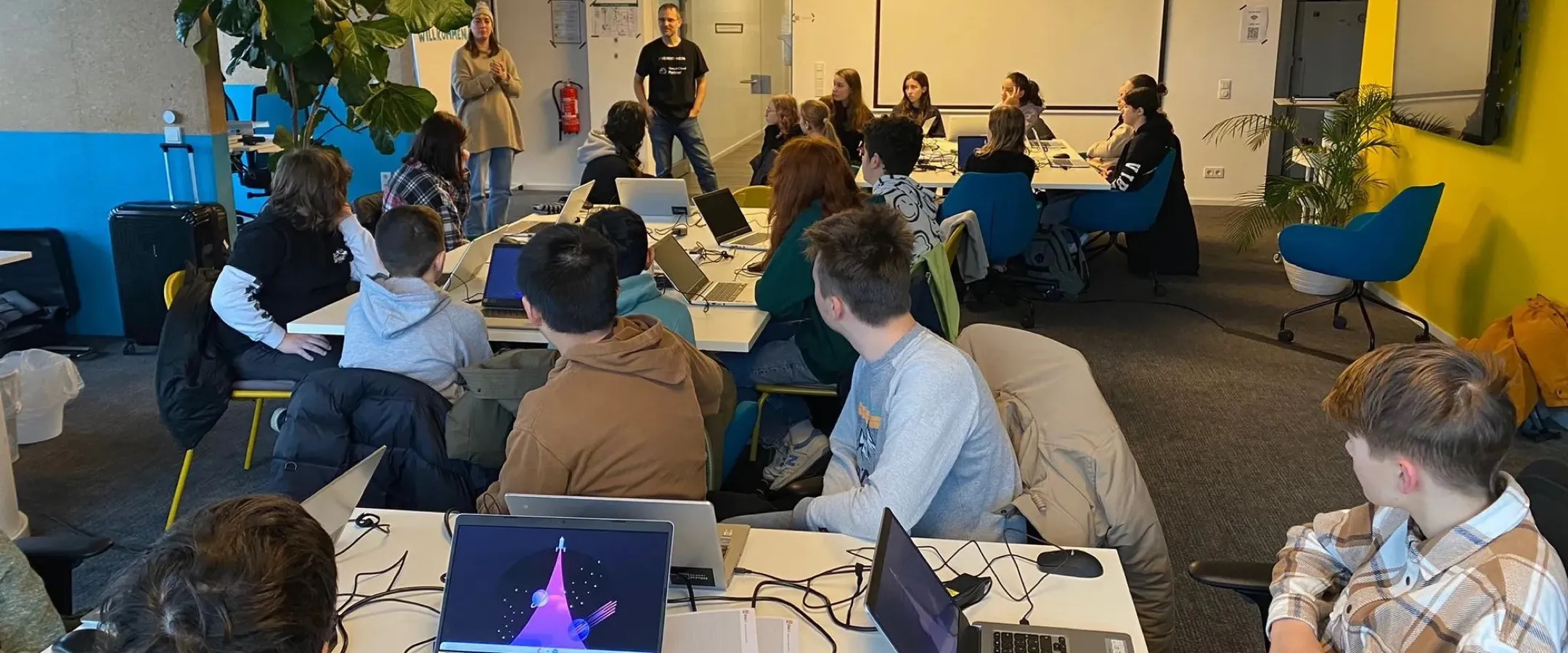 Schülerinnen und Schüler der Oranienschule Wiesbaden bei den Programmiertagen in der Seibert Group, mit Laptops an Gruppentischen.