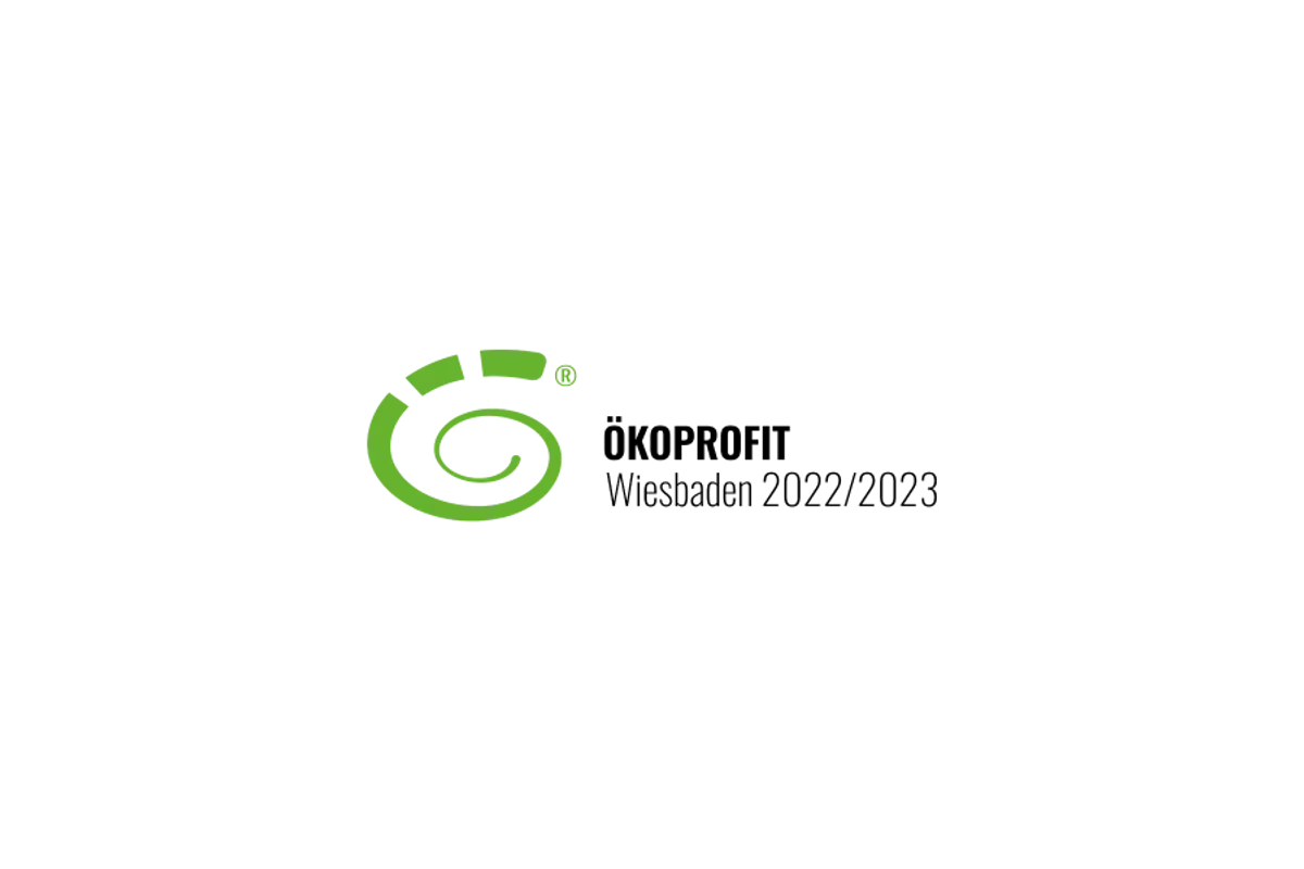 Das Logo von ÖKOPROFIT. Es zeigt eine stilisierte grüne Spirale, die an ein Chamäleon oder eine Schwanzspitze erinnert.