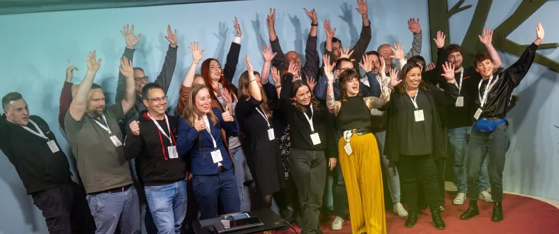 Teilnehmende und Team der T4AT feiern gemeinsam auf der Bühne
