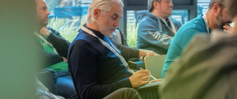 Teilnehmende einer früheren T4AT-Konferenz verfolgen aufmerksam eine Session